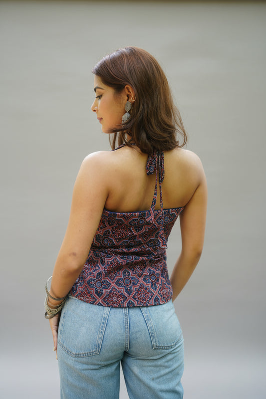 Back view of a halter-neck kurti in a navy and maroon geometric block print. The kurti features a tie-up neckline and a fitted back, styled with light-wash jeans for a bold yet balanced Indo-western look.